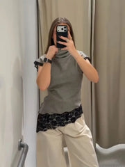 Person taking a mirror selfie wearing a gray sleeveless top, black lace bottom, and beige pants.
