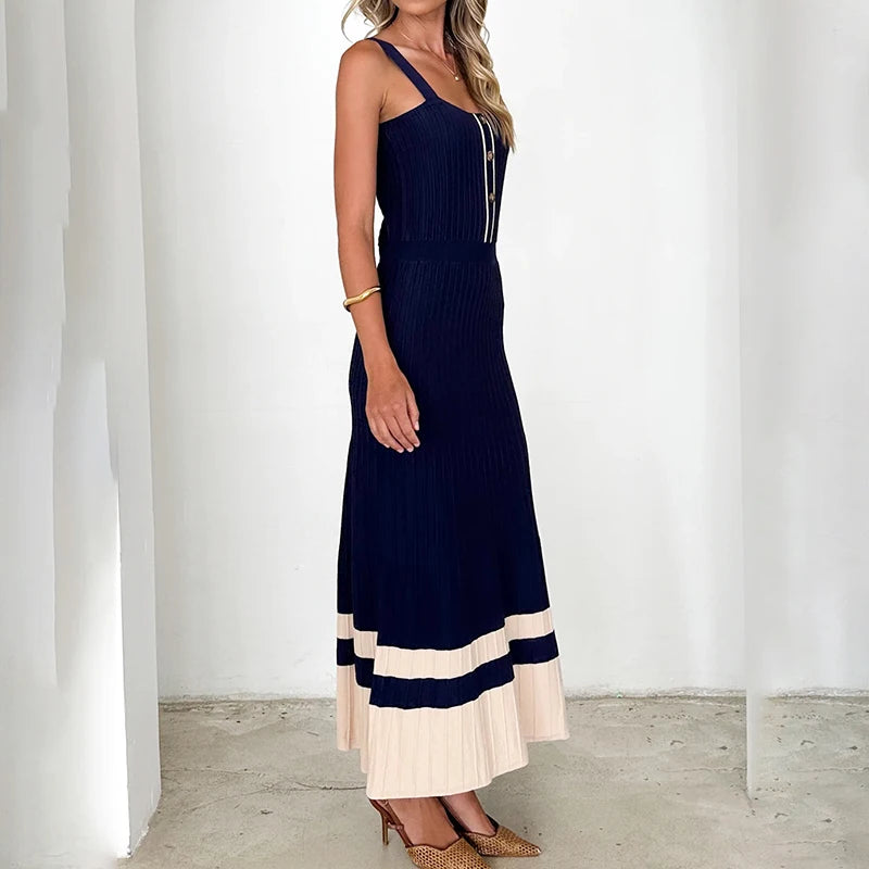 Woman wearing a sleeveless metal button maxi dress in navy and white for summer events against a white background