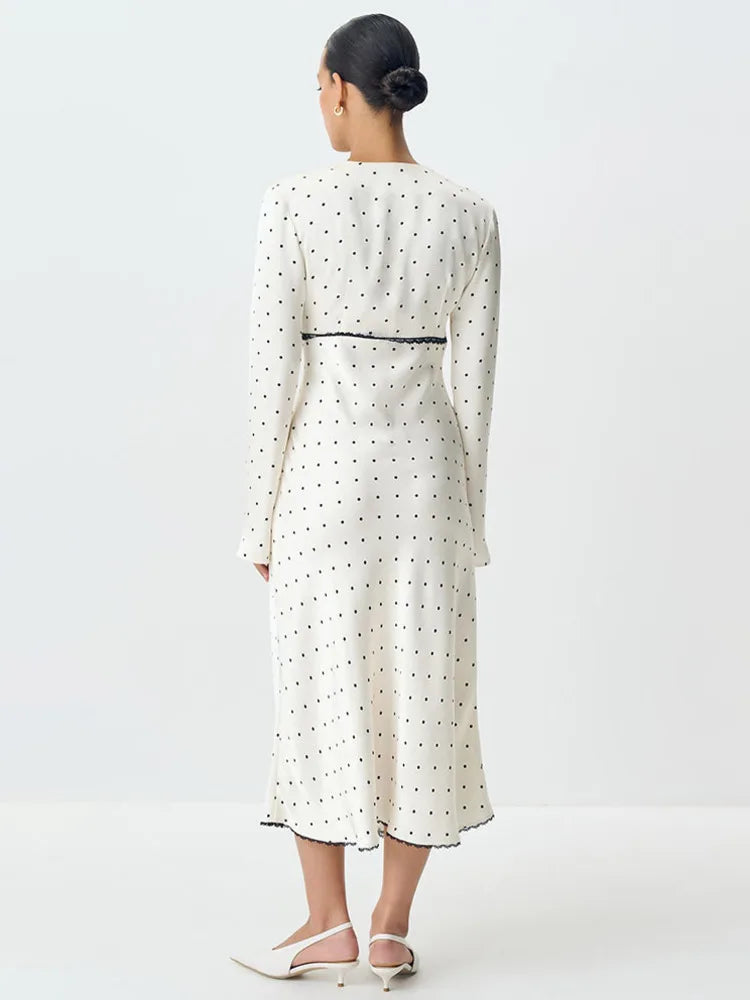 A slim-fit satin evening gown styled with heels and a clutch.