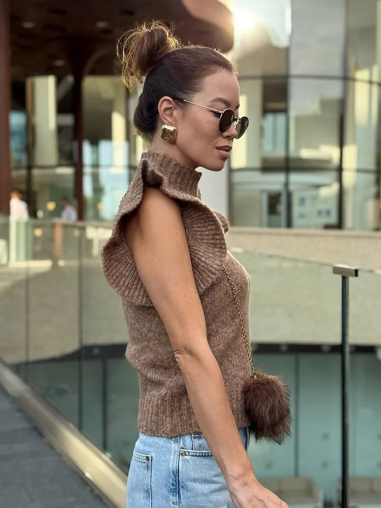 Side angle showing the slim fit and clean lines of the sleeveless knit top worn in an outdoor setting.