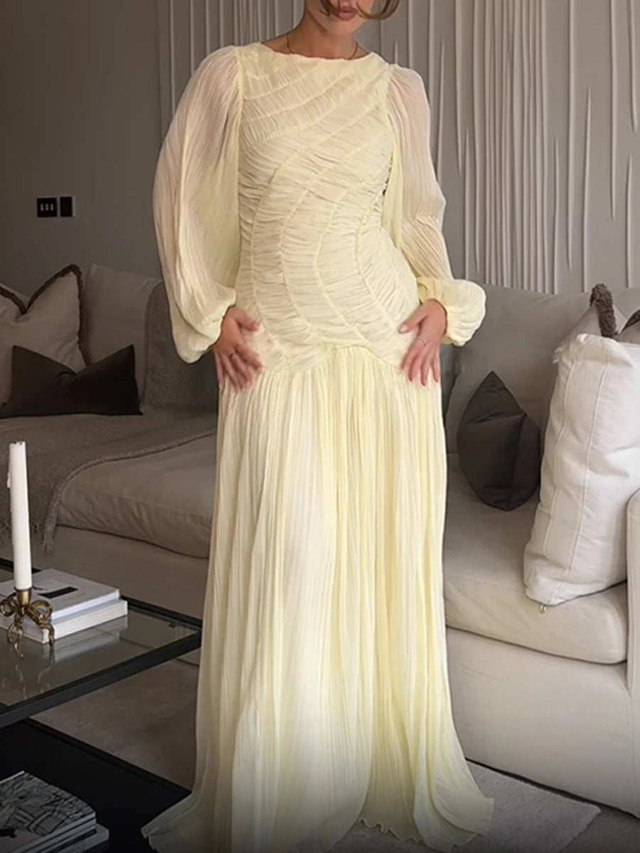 Soft yellow pleated maxi dress styled for elegant living room setting
