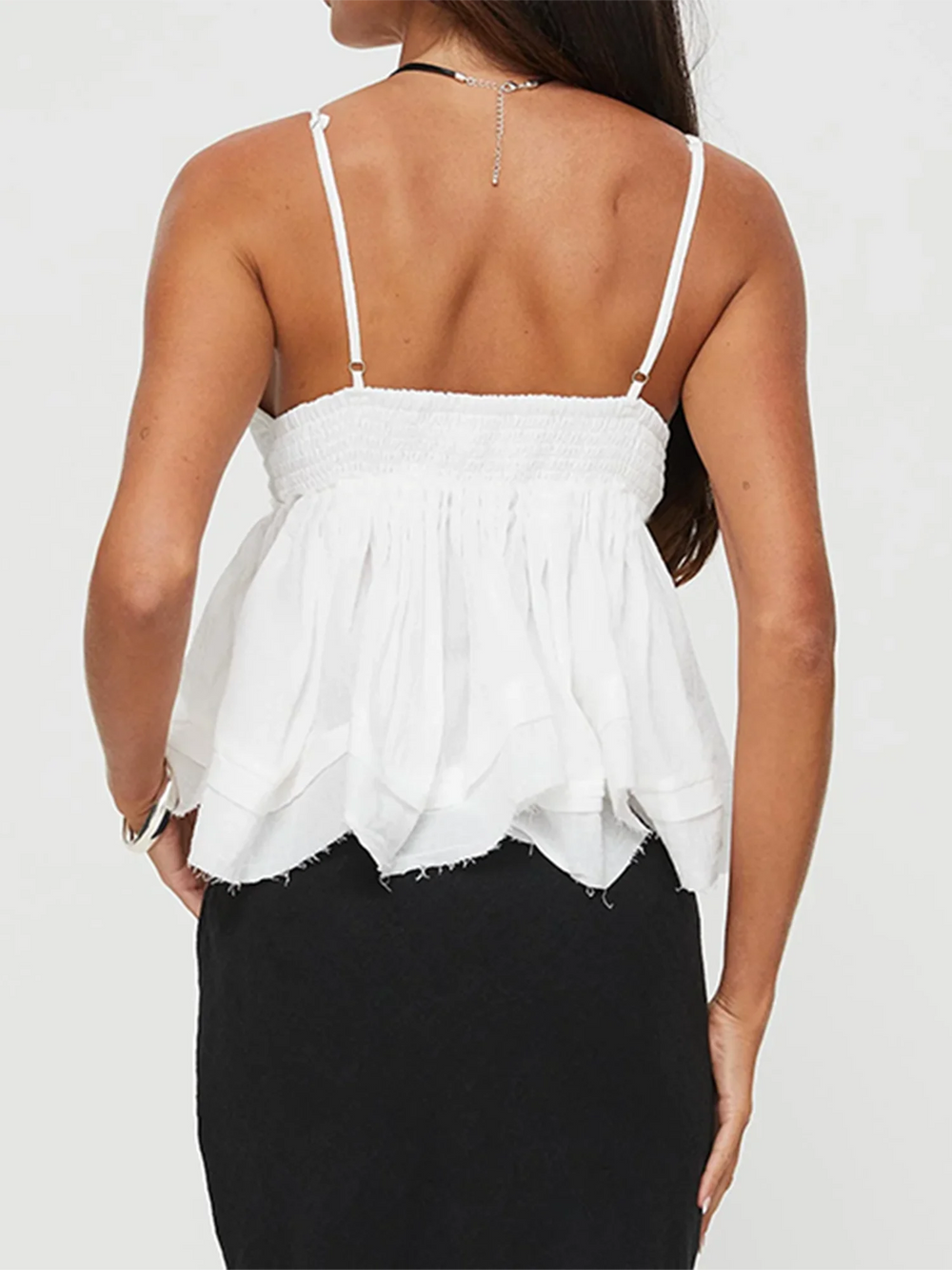 A close-up of the solid-color sleeveless top, showing the ruffle detail.