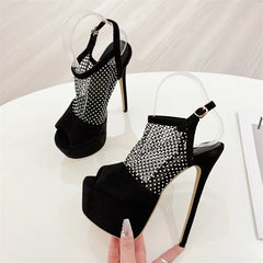 Black high-heeled shoes with rhinestone detailing on a white surface.