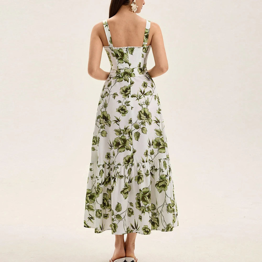 Woman wearing a sleeveless square neck sundress with a flattering empire waist with green flowers on a white background