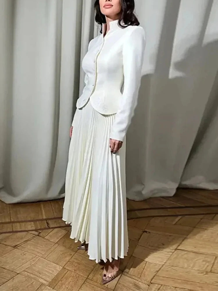 Detail view of the pleated skirt in motion, showing soft drape and refined movement.