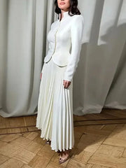 Detail view of the pleated skirt in motion, showing soft drape and refined movement.