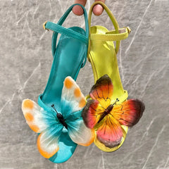 Statement colourful butterfly outdoor dress sandal for a wedding or gala event on a textured surface