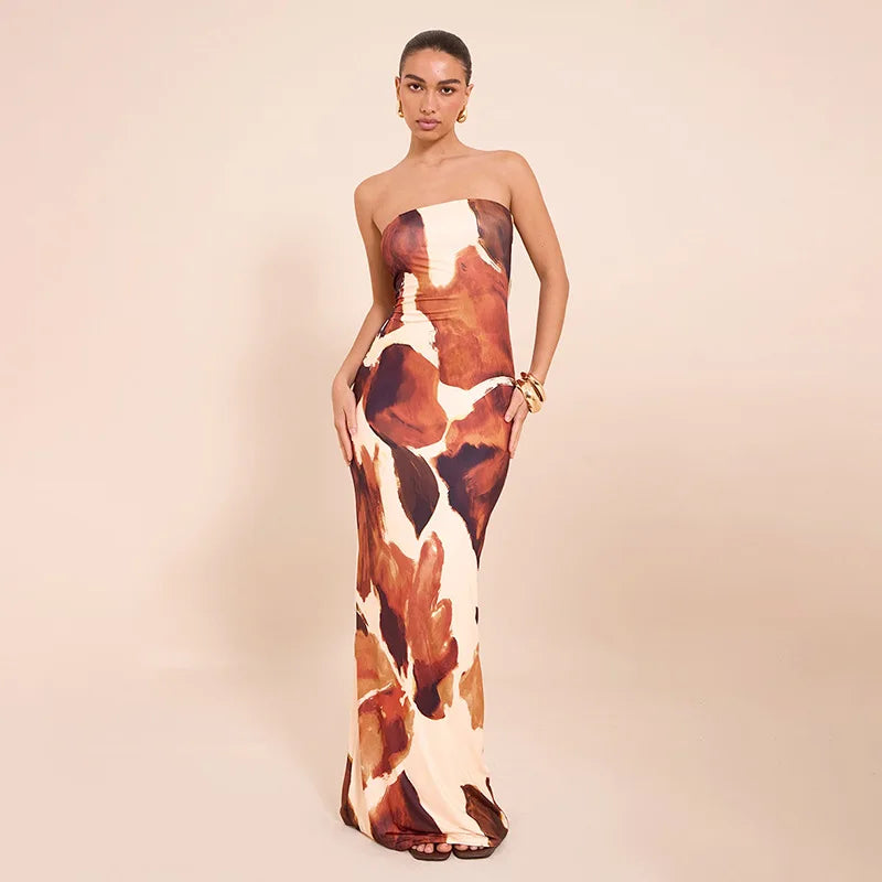 Woman wearing  a strapless abstract print maxi dress against a beige backdrop with a cow print pattern on a beige background