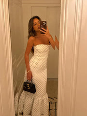 side angle showing slim fit and flounce trumpet hem of polka dot dress