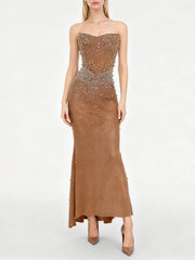 A strapless embellished mermaid dress revealing tapered silhouette and fitted bodice with clean zipper shaping.