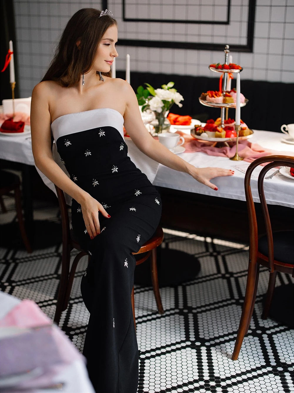 Editorial shot of black bow cape evening dress styled for a formal event