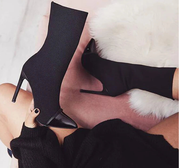 A woman is wearing a pair of high-heel ankle boots.