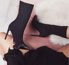 A woman is wearing a pair of high-heel ankle boots.