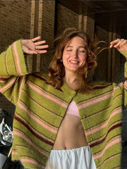 Woman wearing a green and pink striped cardigan in an urban setting