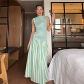 Woman wearing green and white striped pleated maxi dress for summer