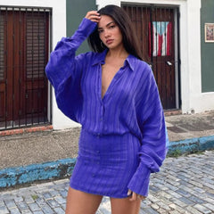 A woman modeling a striped polo long-sleeve mini dress.