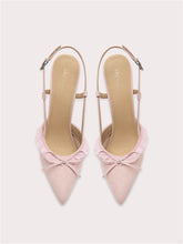 A pair of pink suede sandals with a lace bow.
