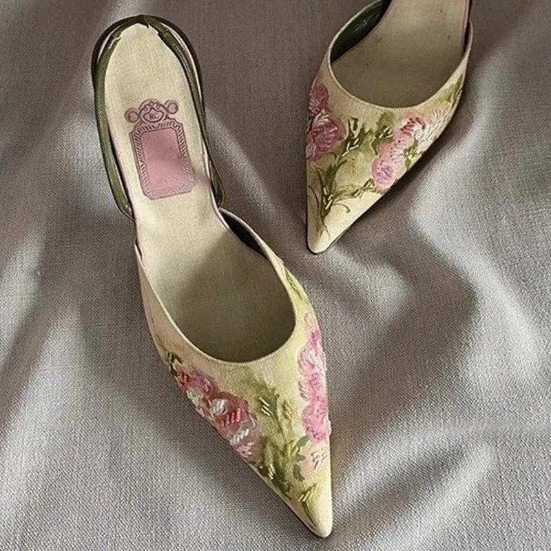 Pair of floral high-heeled shoes on a textured fabric background