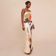 Woman wearing a backless strapless dress in earthy abstract print on a beige background