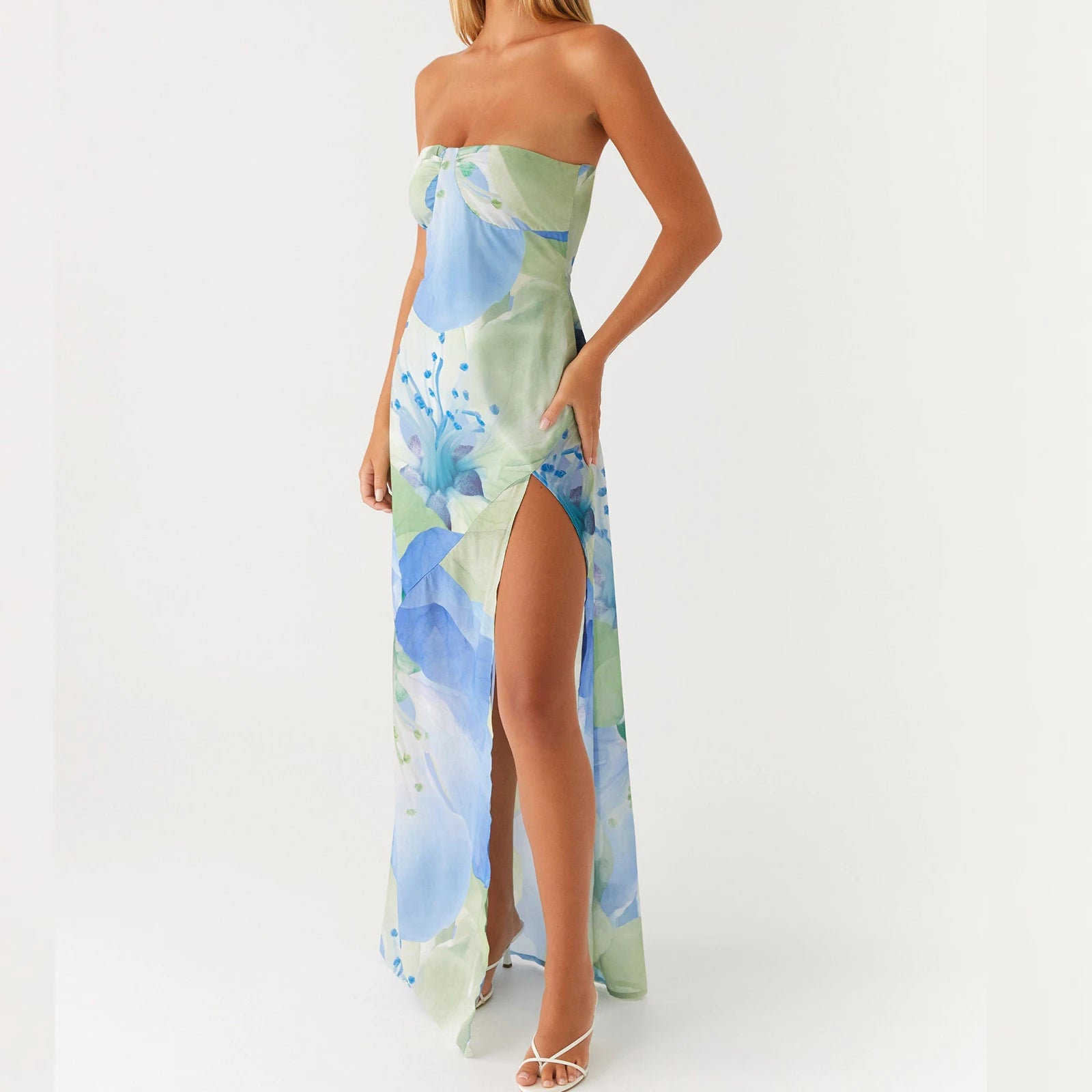 Woman wearing a strapless elegant floral slit dress perfect for beachside parties and summer weddings , with white back ground