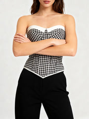 Close-up of a structured gingham corset top with clean neckline and fitted waist detail.