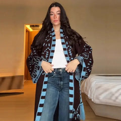 Full-length look focusing on the tassel hem and graphic border motifs of the long cardigan, creating movement with every step.