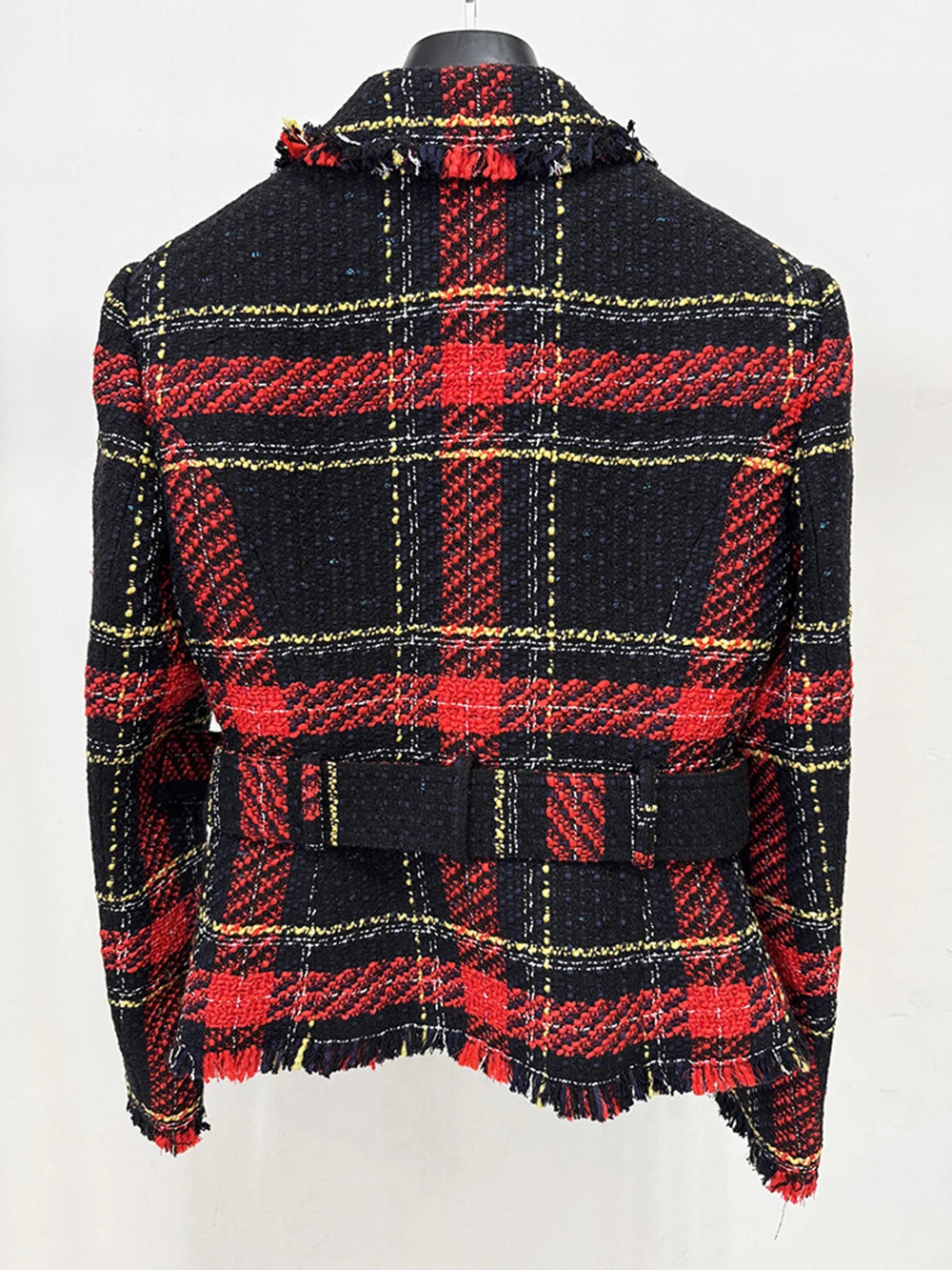 Detail focus on the gold buckle belt and tweed texture, showing the structured finish and clean tailoring through the waist