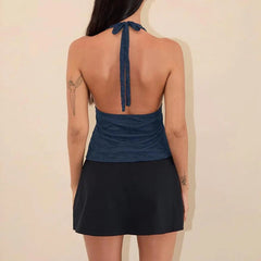 A tie-up halterneck camisole styled with high-waisted shorts for a casual look.