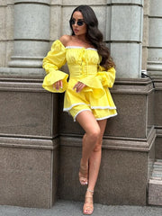 Woman in a two-piece yellow outfit ideal for travel and weekend outings standing against a stone wall.
