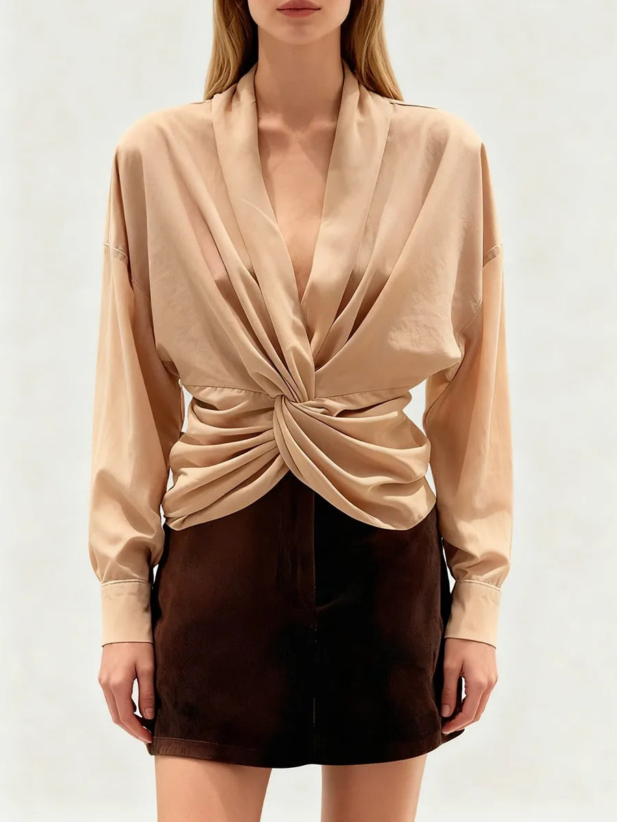 Model wearing a draped blouse with a twisted front detail.