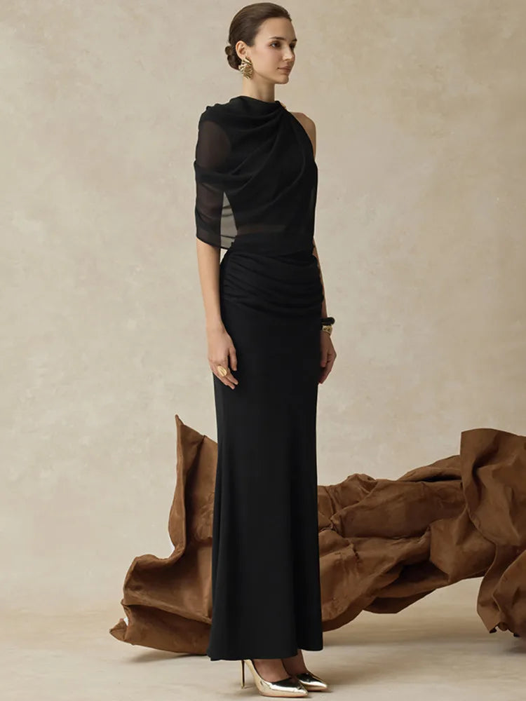 Three-quarter pose showing the coordinated two-piece silhouette with a sleek waistline and refined evening styling against a neutral backdrop.