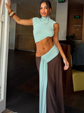 Woman wearing a two-tone draped cutout maxi dress indoors