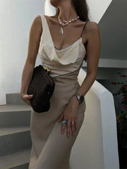 Woman wearing a two-tone cowl neck satin maxi dress on a staircase