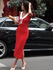 Slim fit red polka dot dress styled with white heels next to black car