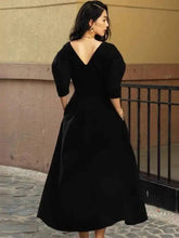 Back view of a V-neck A-line dress with short puff sleeves, showing an elegant open-back shape and a smooth ankle-grazing skirt.