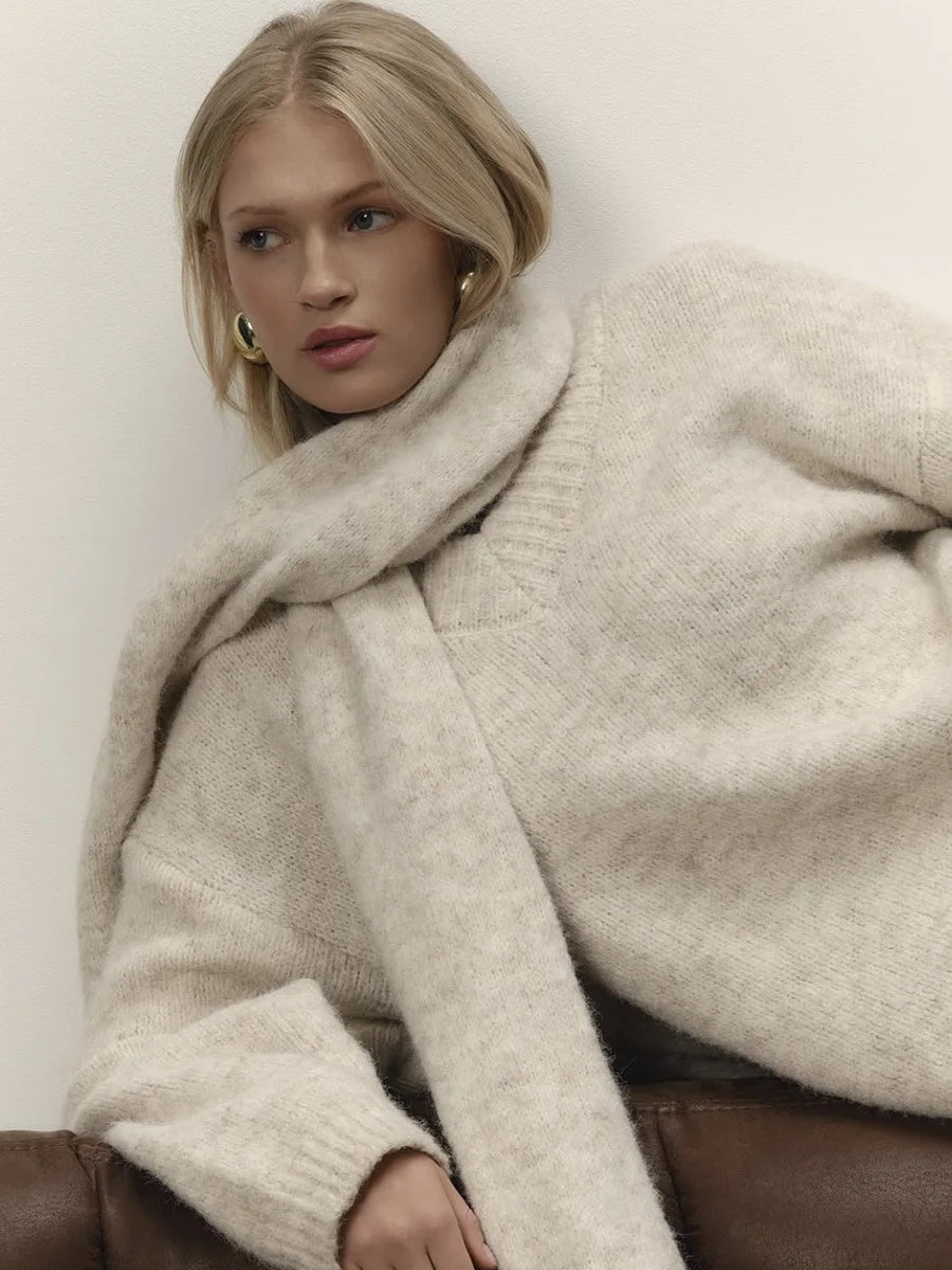 Knit sweater styled casually for an indoor setting, highlighting the relaxed fit and long sleeves.