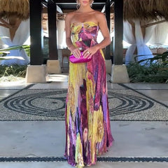 Colorful floral maxi dress styled with pink clutch in tropical resort setting