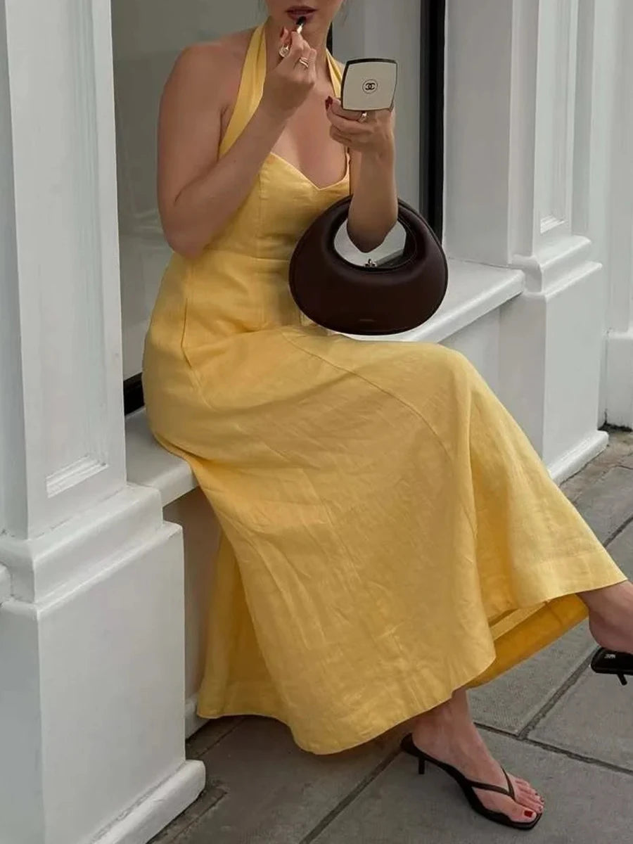 Romantic yellow summer dress with open back and flattering waist
