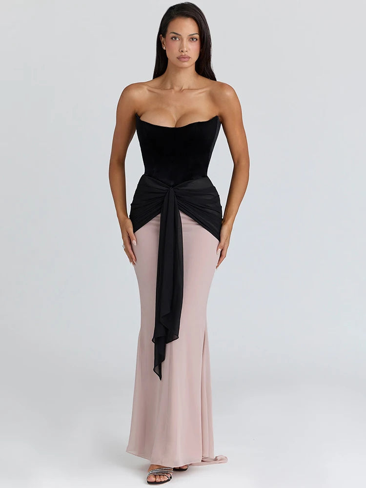 Strapless velvet corset dress with dramatic tie detail for a refined evening look.