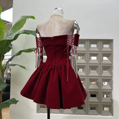 Hem detail showing lace trim beneath the pleated puff skirt on a burgundy velvet corset mini dress.