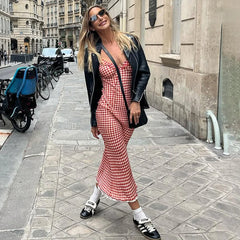 Woman in a Vintage-inspired red plaid dress with lace-up back and ankle length walking on a city street.