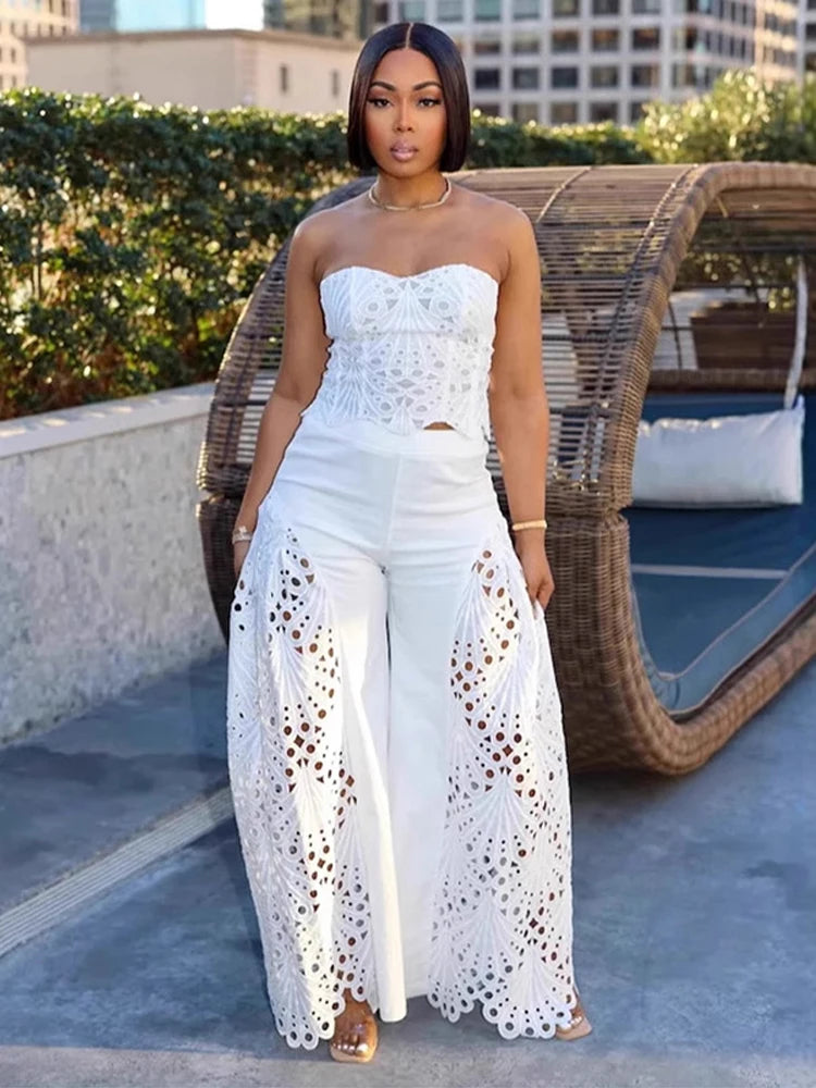 Woman wearing white strapless top with crochet panels and wide-leg pants