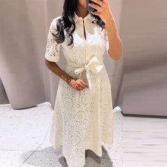 Woman wearing white embroidered belted maxi dress with lapel collar