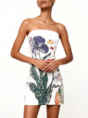 Close-up of vibrant beaded florals on a white cocktail mini dress