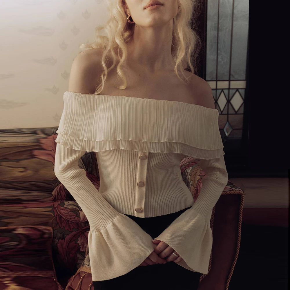 White off-shoulder pleated knit sweater styled in cozy room