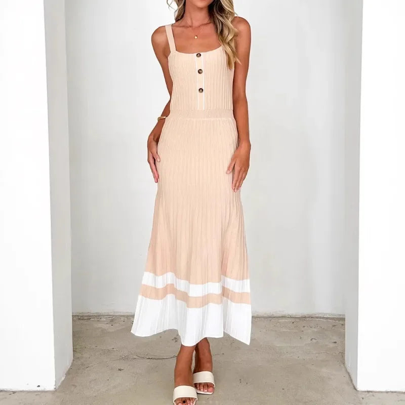 Woman wearing a white patchwork ankle-length knitted dress styled for chic spring-summer occasions against a plain background