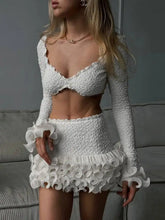 Woman wearing a white lace outfit in a neutral setting