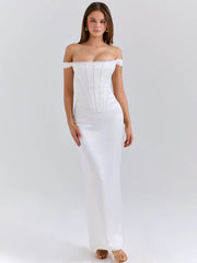 Woman wearing a white satin off-shoulder gown with a backless design on a white background