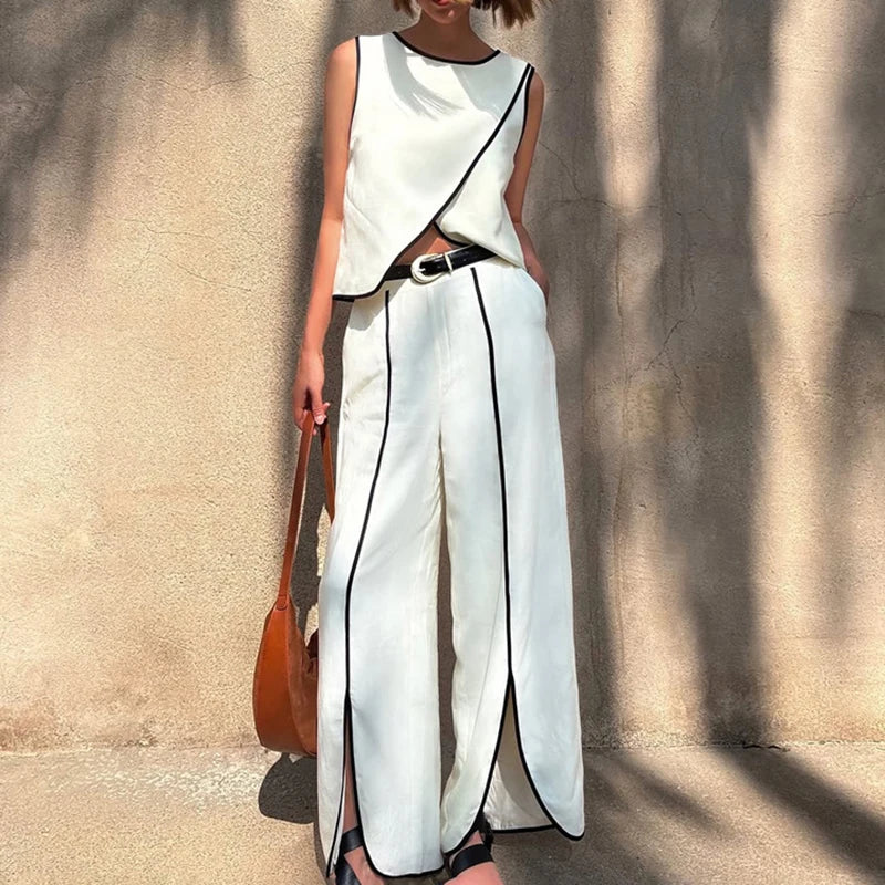 White two-piece vest and trouser set with black piping styled outdoors