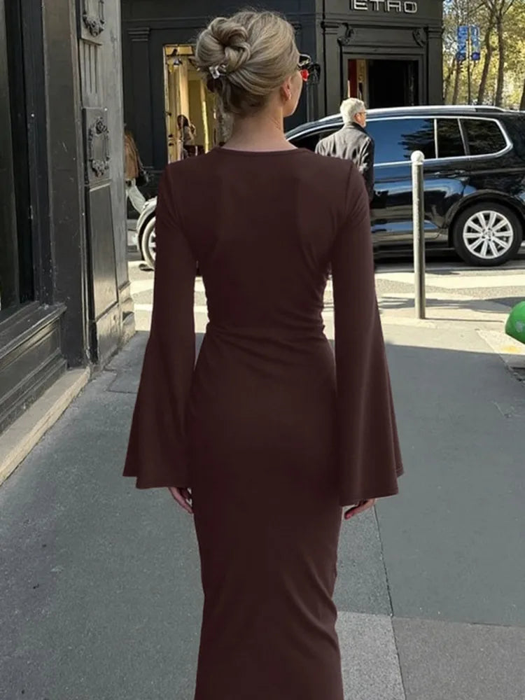 Woman in a brown dress walking on a city street